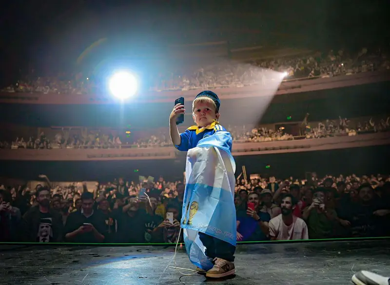 Hasbulla on stage taking a selfie in front of a packed arena