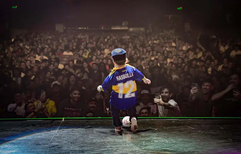 Hasbulla in a number 12 football jersey in front of a huge crowd